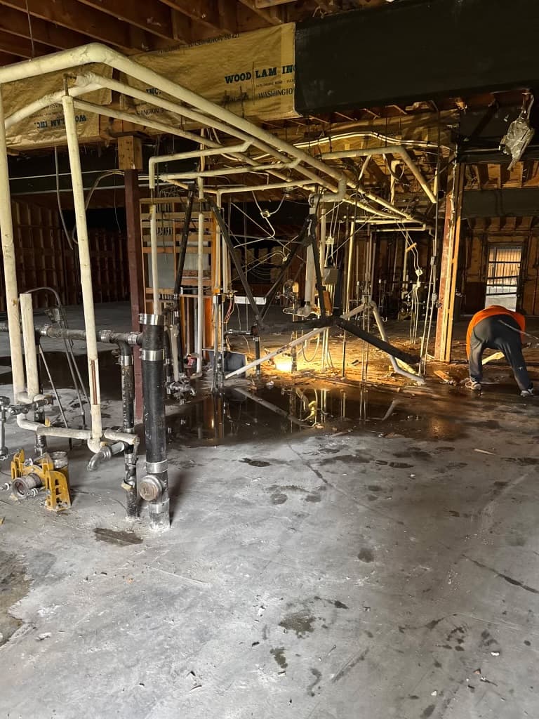 Commercial interior opened for repipe planning with exposed plumbing lines