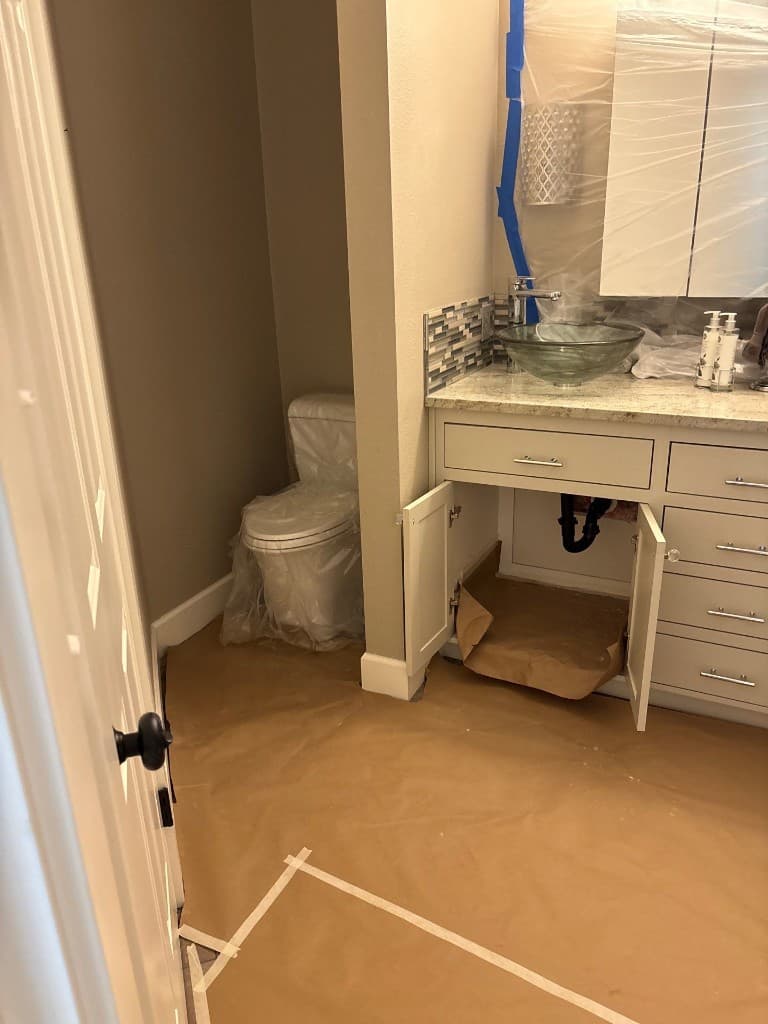 Bathroom and vanity area protected during repipe and restoration work