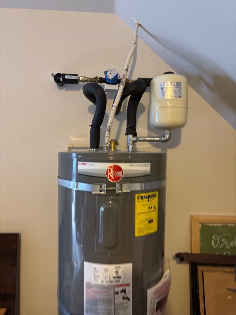 Completed water heater connection with updated piping after repipe scope